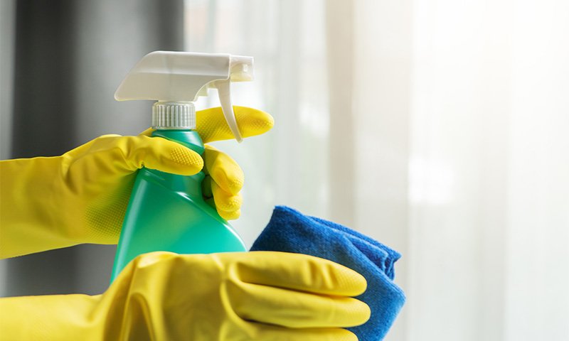 maos-segurando-um-spray-de-limpeza-e-pano